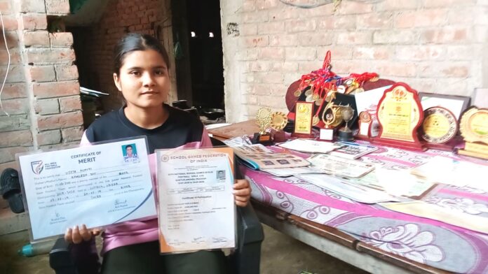 मेडल एवं प्रमाणपत्र को दिखाती नेशनल अवार्ड से सम्‍मानित विजेता